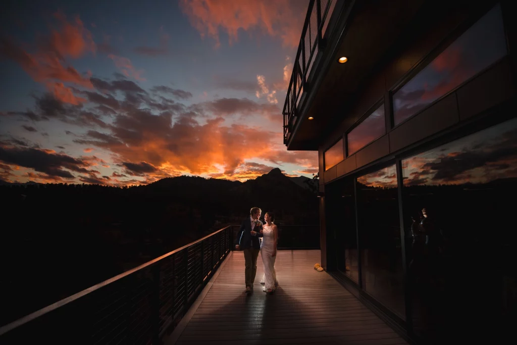 Bride and Groom walk together smiling at sunset at their Estes Park, CO wedding.