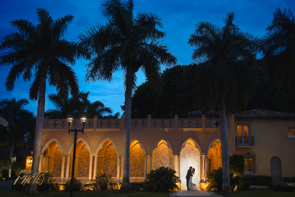 Wedding couple kissing at their Moroccan arched Boca Raton wedding venue.