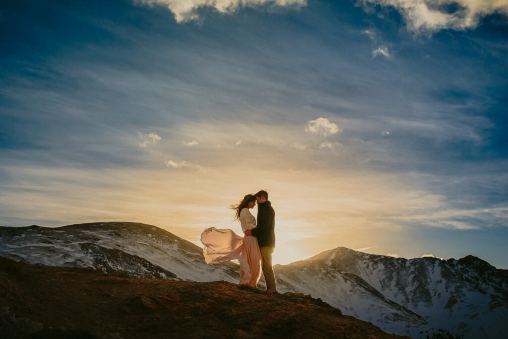 Colorado couple hugs at sunset in the Rocky Mountains.