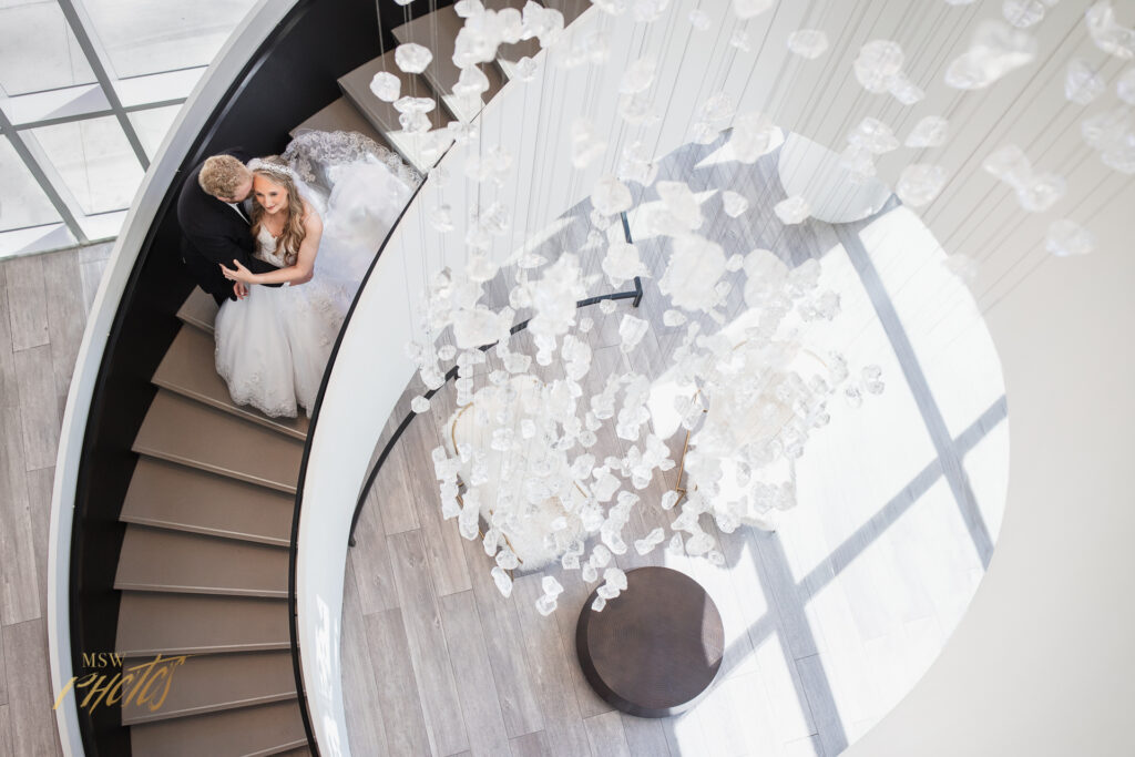 Denver wedding couple embracing in front of a chandelier.