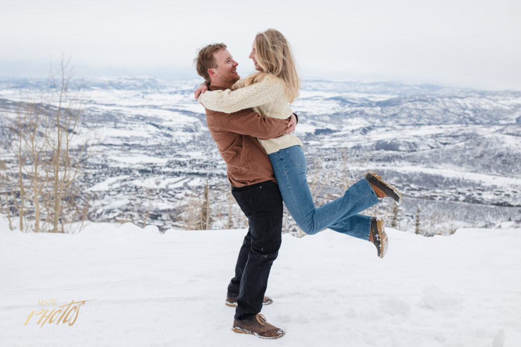Engaged Colorado couple embracing in the snow in Steamboat Springs, CO.