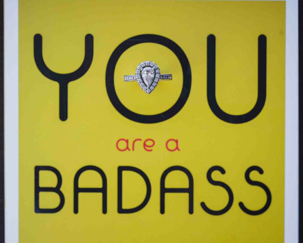 A wedding ring placed on top of a book titled "You Are A Badass."